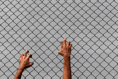 Close-up of hand on chainlink fence