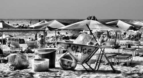 Group of people on beach against clear sky