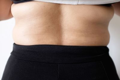 Midsection of woman standing against white background