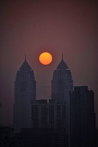 Modern buildings against sky during sunset