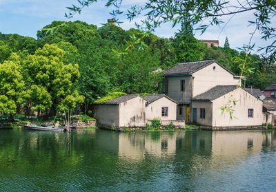 House by river against building and trees