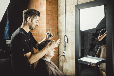 Side view of a young man sitting in the wall