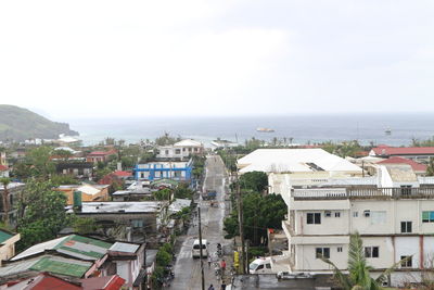 Aerial view of city by sea against sky