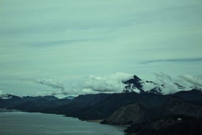 Scenic view of sea and mountains against sky