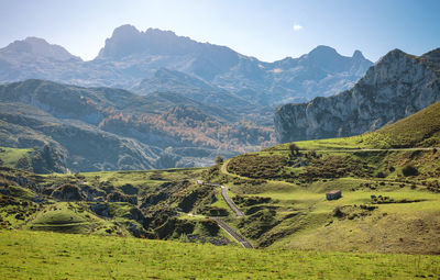 Scenic view of field and mountains against sky