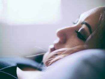 Close-up of thoughtful woman lying at home