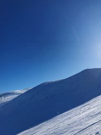 Scenic view of snowcapped mountains against clear blue sky