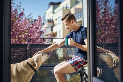 Man and dog looking at window