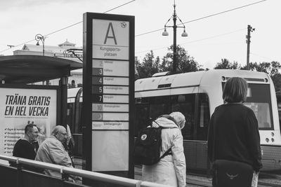 Rear view of people walking on train in city