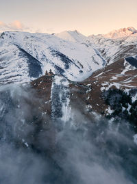 Scenic view of snowcapped mountains against sky during sunset