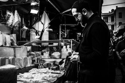 Side view of man buying food at stall from grand bazaar
