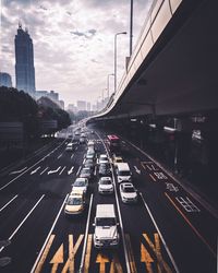 Vehicles on road in city against sky