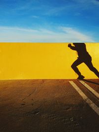 Shadow of man on wall running outdoors