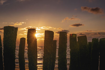 Panoramic shot of wooden post against sky during sunset