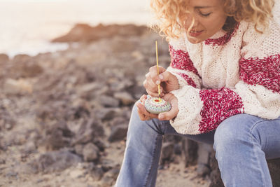 Close-up of girl playing on sand at beach