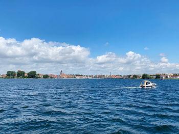 Sailboats sailing in sea against sky