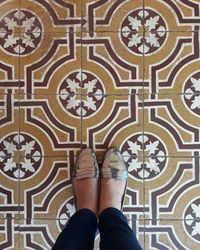 Low section of woman standing on tiled floor