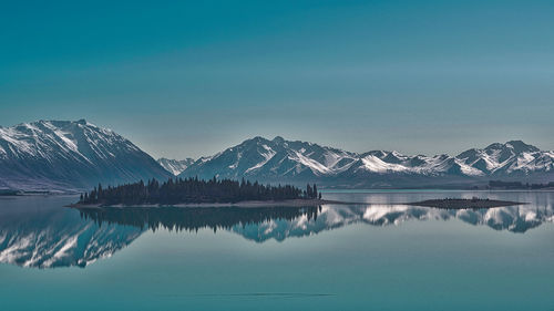 Scenic view of lake and snowcapped mountains against sky