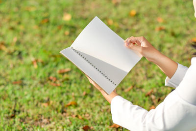 High angle view of man holding paper on field