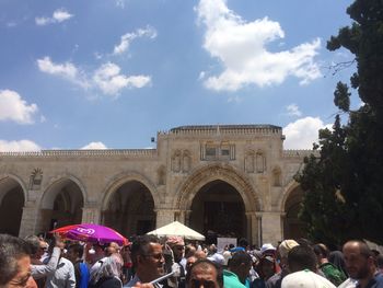 Group of people in building against sky