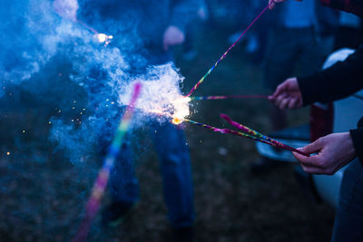 People holding sparkler at night