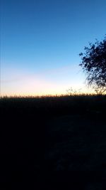 Scenic view of silhouette field against clear sky during sunset