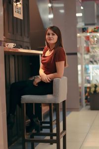 Portrait of a smiling young woman sitting on chair