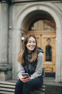 Portrait of smiling young woman using mobile phone