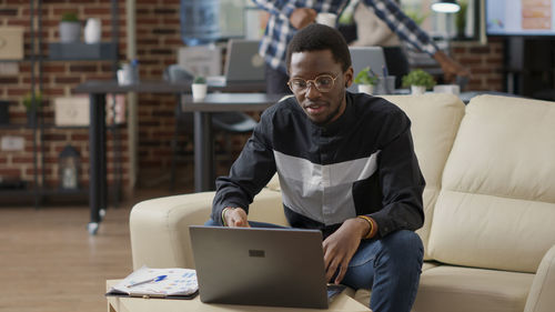 Young man using laptop while sitting in library