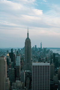 Modern buildings in city against cloudy sky