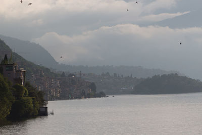 View of city by sea against sky