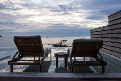 Chairs on beach against sky