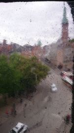 Road seen through wet window in rainy season