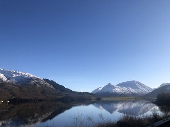 Scenic view of snowcapped mountains against clear blue sky