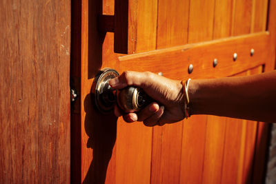 Close-up of hand holding closed door