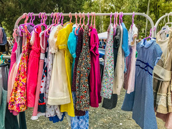 Various clothes hanging in rack for sale at market