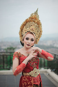 Portrait of smiling young woman custome traditional of bali standing outdoors