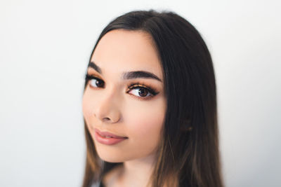 Close-up portrait of a beautiful young woman over white background