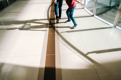 Low section of people walking on tiled floor