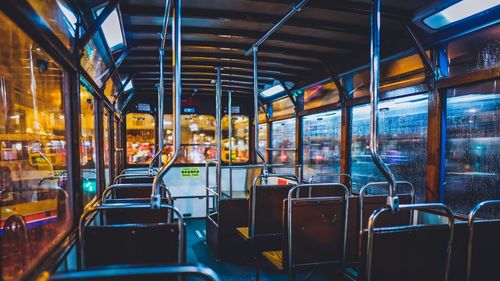 Empty seats in illuminated tramp at night