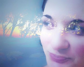 Close-up portrait of young woman against trees