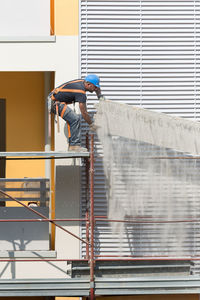 People working at construction site against building