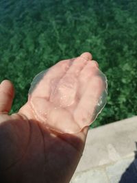 Close-up of human hand against water