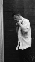 Full length of young man standing against wall