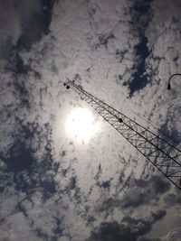 Low angle view of silhouette crane against sky