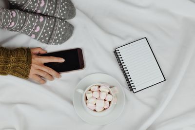High angle view of woman using mobile phone on bed