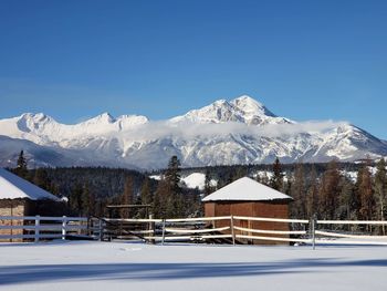 Houses against snowcapped mountains against clear sky