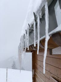 Close-up of icicles against clear sky during winter
