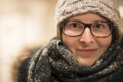 Close-up portrait of beautiful woman wearing scarf and knit hat with eyeglasses