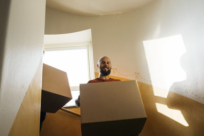 Man carrying cardboard box at staircase